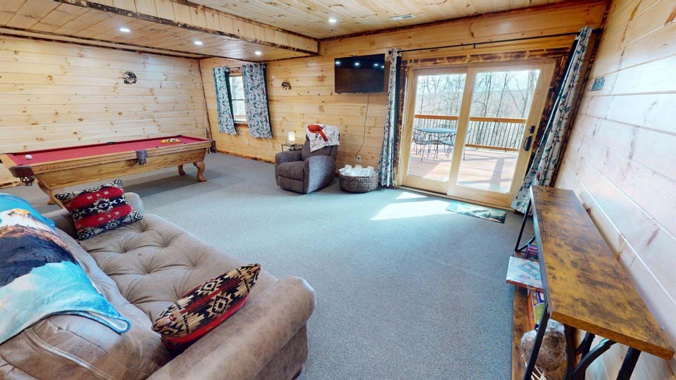 willifeesp-mar26-11 Family playing a board game together in the cozy cabin living room.